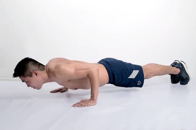 Hombre joven haciendo planchas para trabajar abdominales