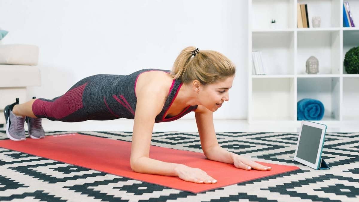 mujer joven haciendo un ejercicio de plancha - ejercicio para mejorar los abdominales